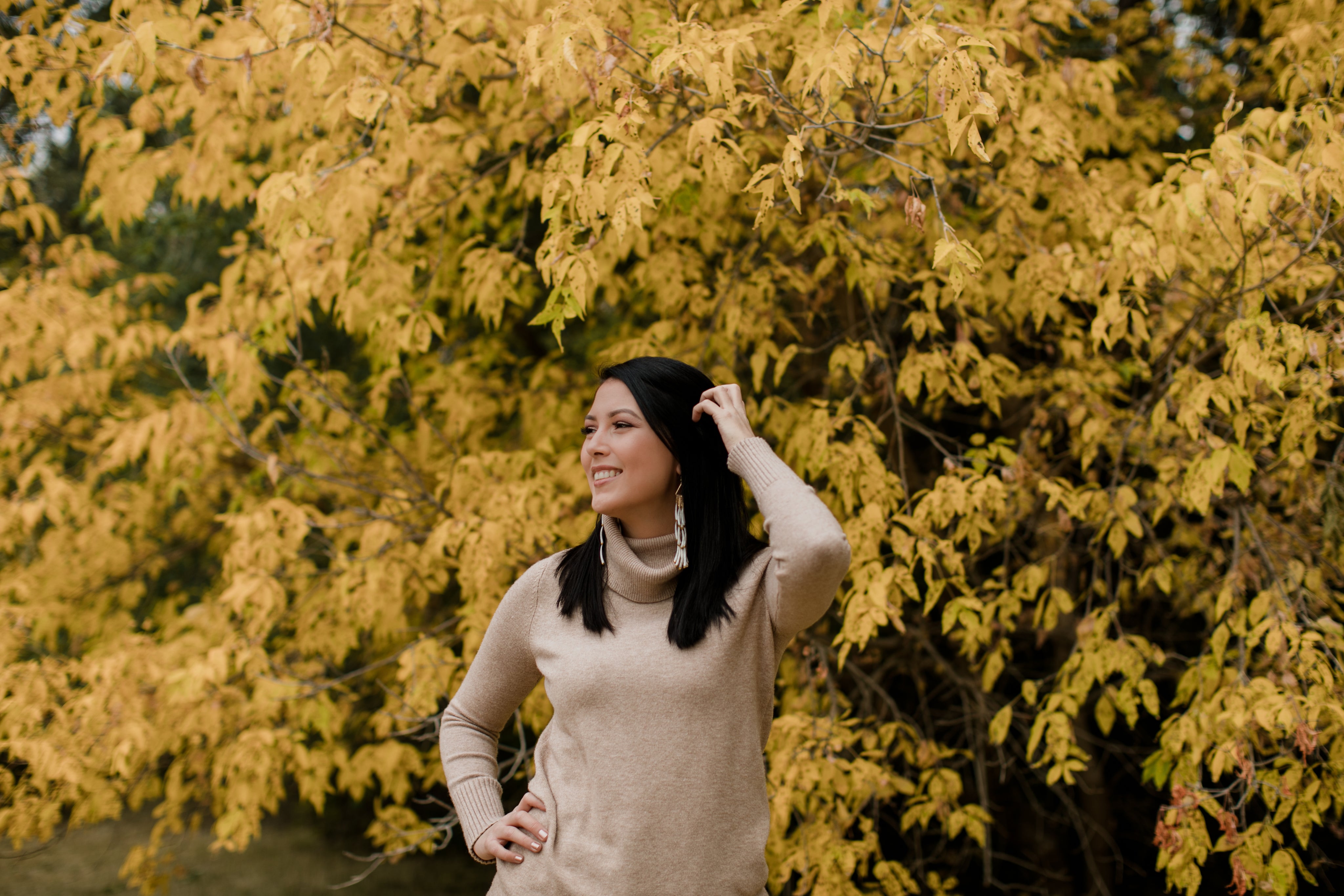 files/woman-in-tan-sweater-smiles-standing-against-yellow-trees.jpg